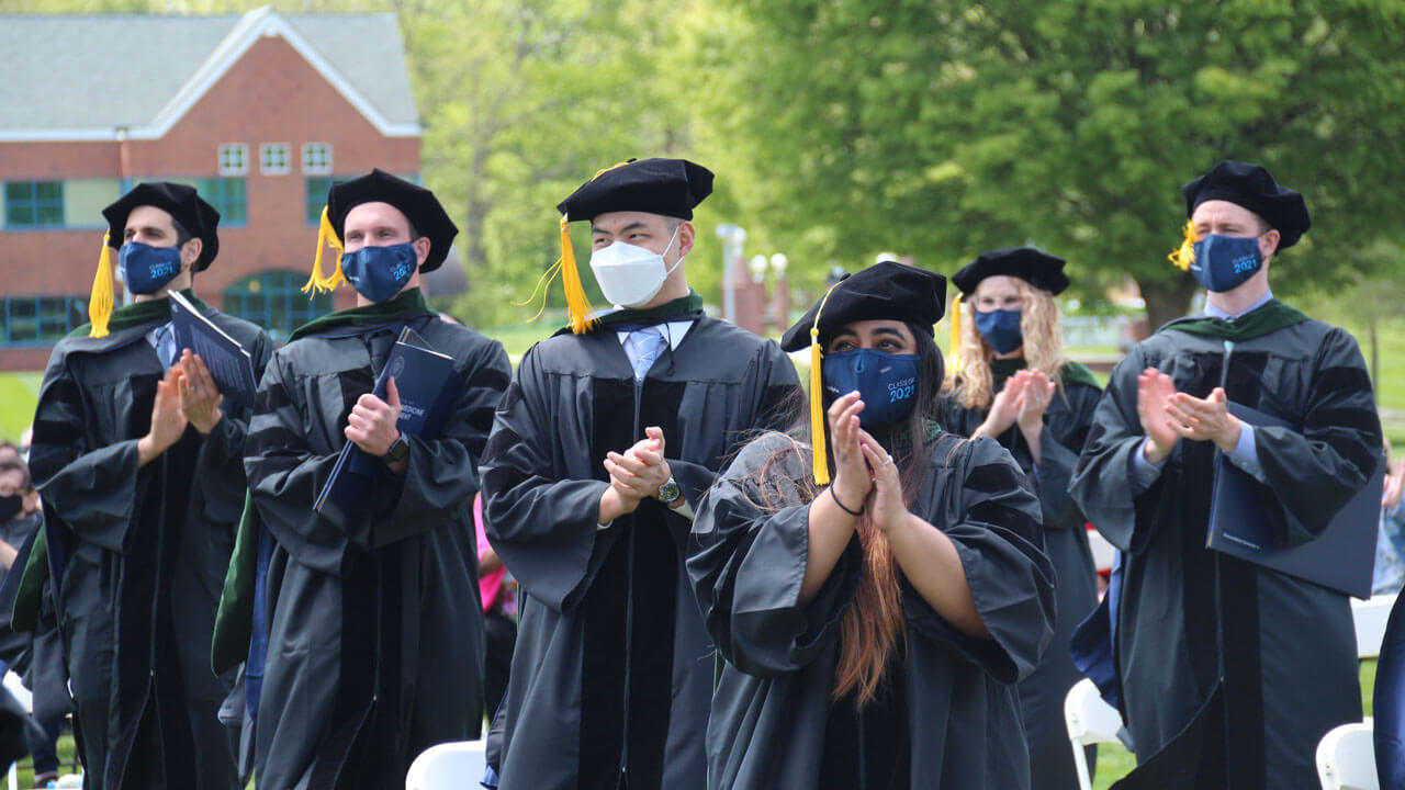 School of medicine graduates clapping after commencement concludes