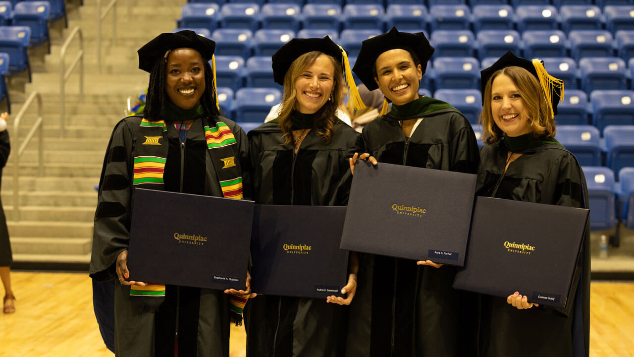 Medicine students smiling and holding their diplomas
