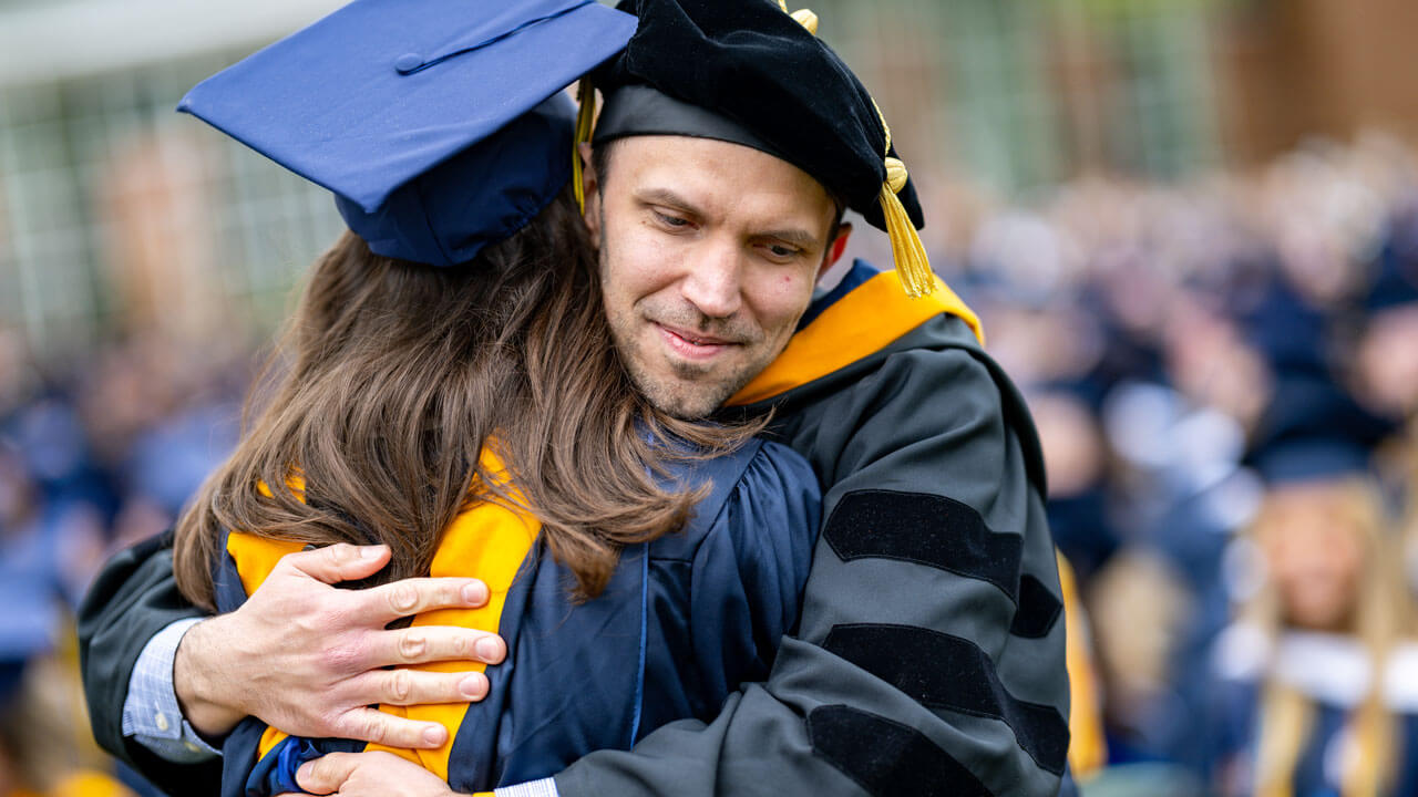 Professor hugiging a SOC graduate