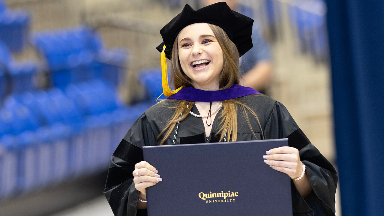 Graduate smiles with diploma