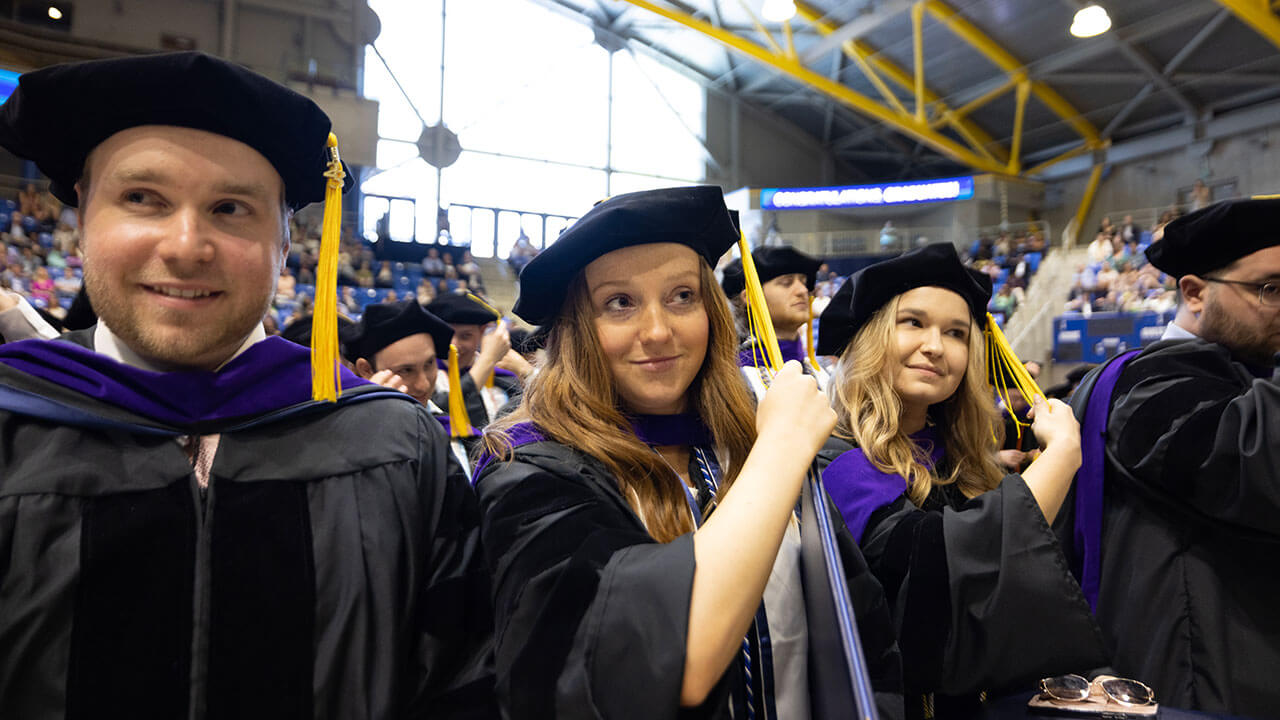 Law graduates smile as they flip their tassels