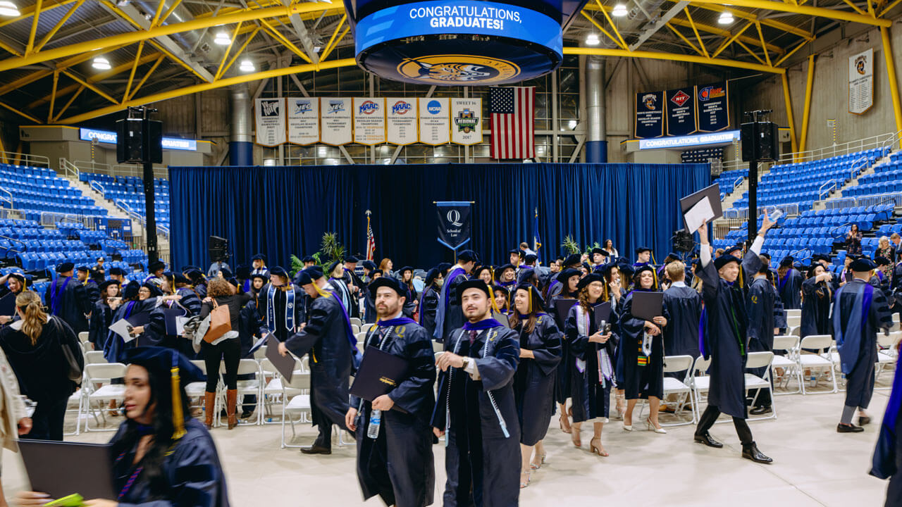 School of Law students walking around in their cap and gowns in M&T Bank Arena