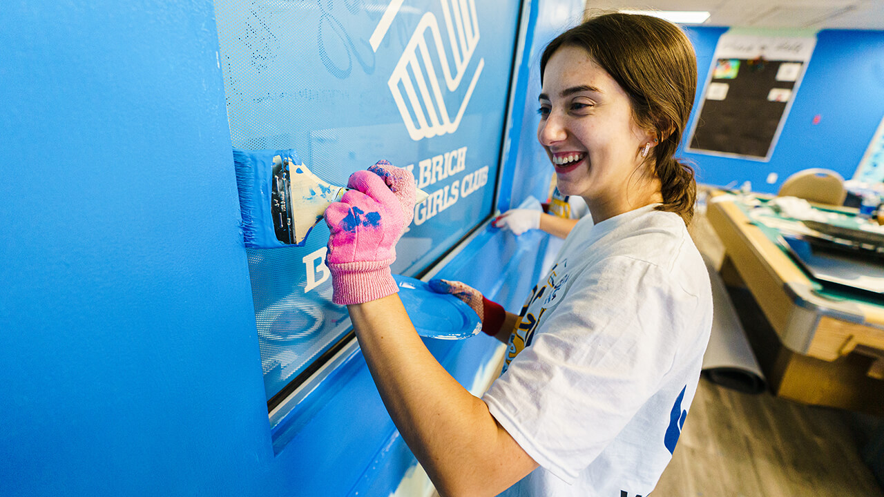 A student paints a wall.