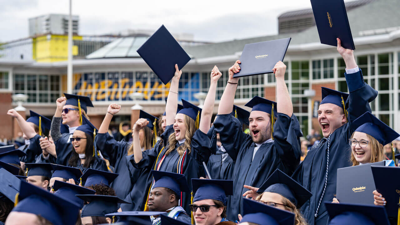 Quinnipiac SOC graduates stand up out of their seats to cheer