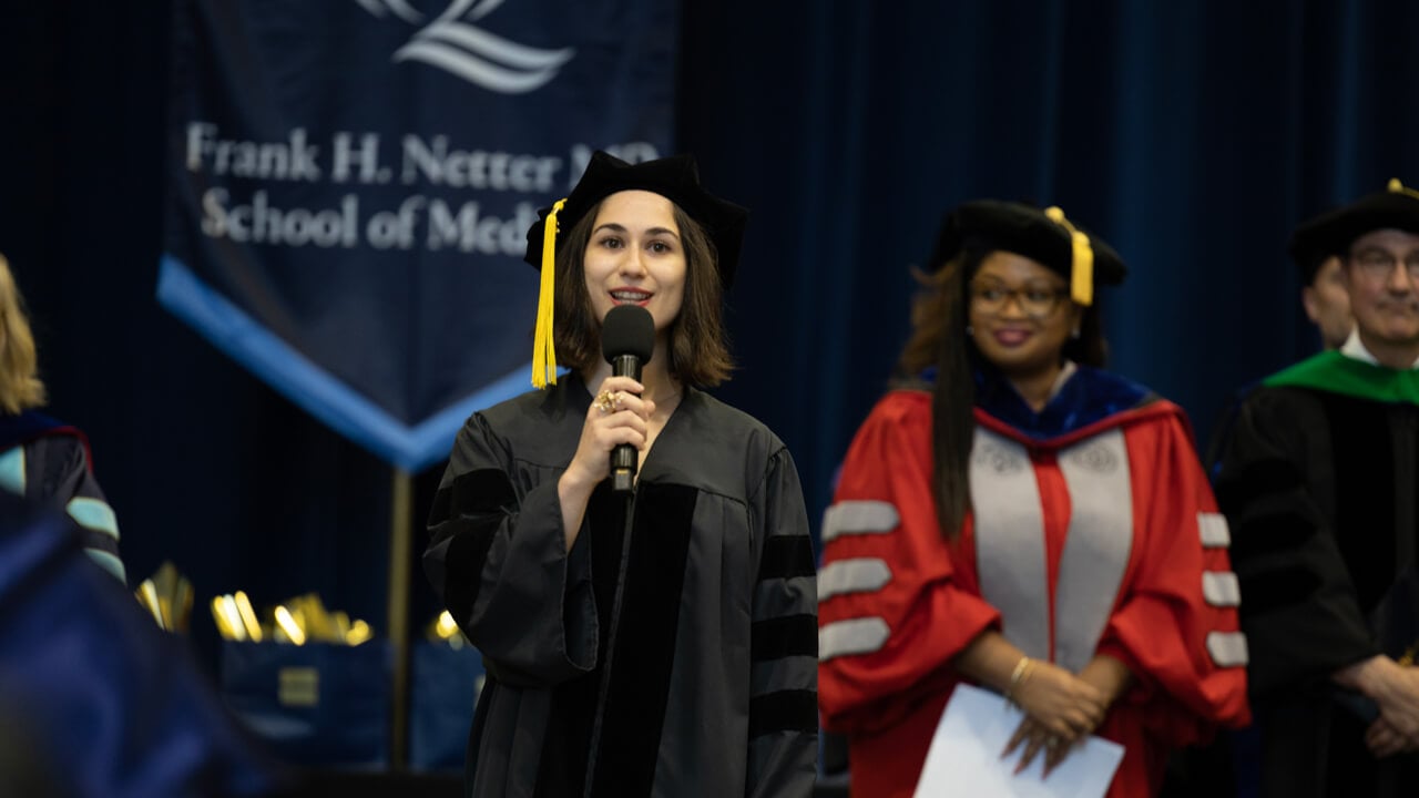 Anoush Calikyan, MD ‘23 holds a microphone and sings on stage