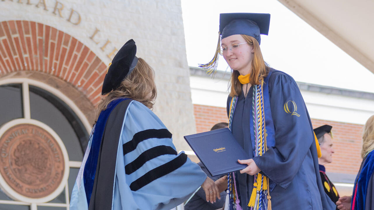 Lauren Jerram shaking hands with her diploma
