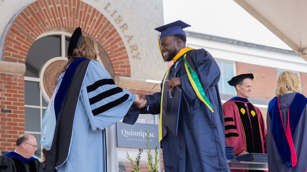 Graduate student shaking hands with faculty
