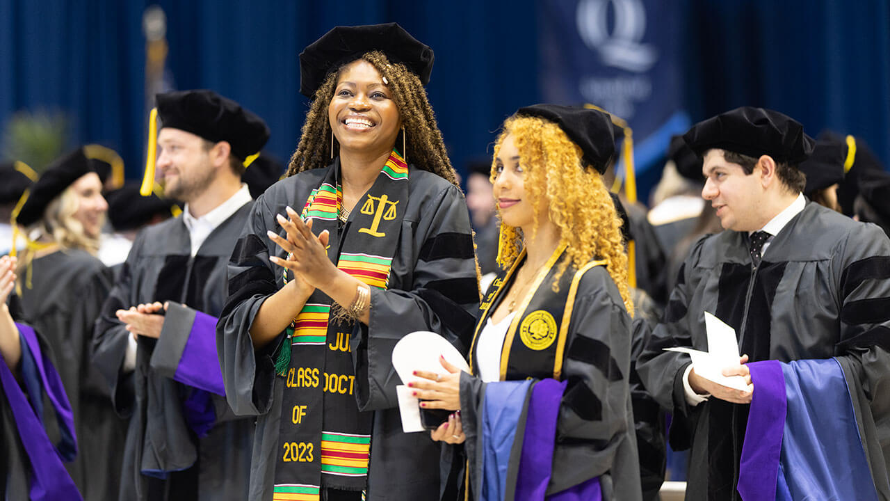 Graduates stand on stage and celebrate their accomplishments during their graduation ceremony