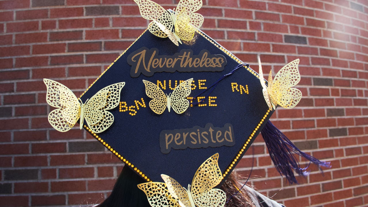 Graduation cap decorated with butterflies and says 