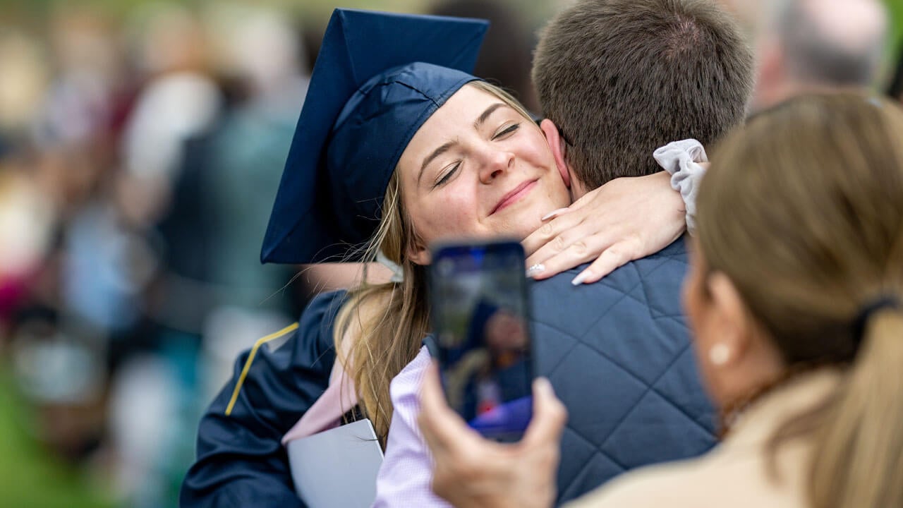 SOC Graduate hugging their family member