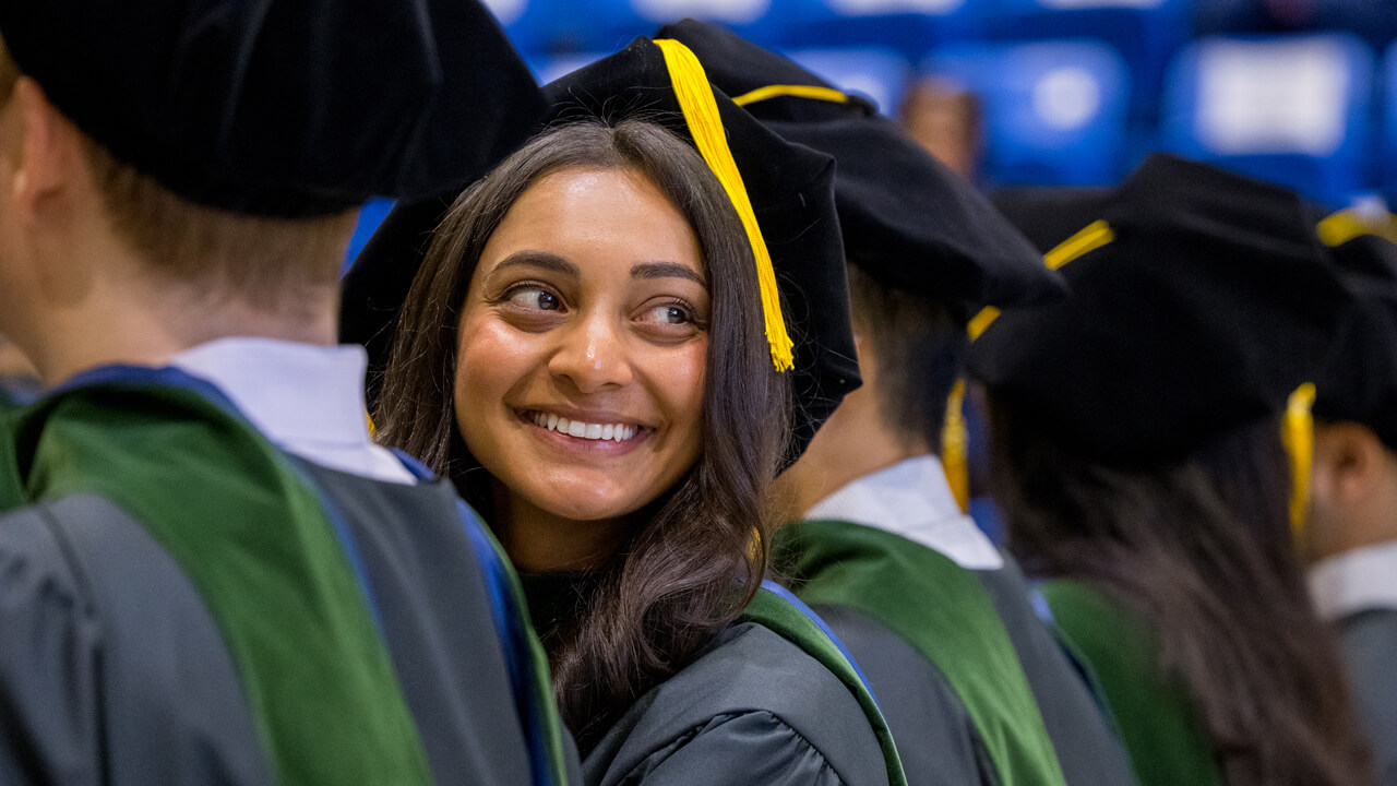 A graduate smiles over her shoulder