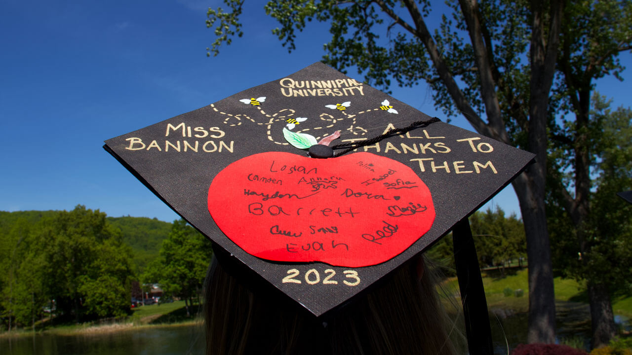Graduation cap decorated with apple and students names written
