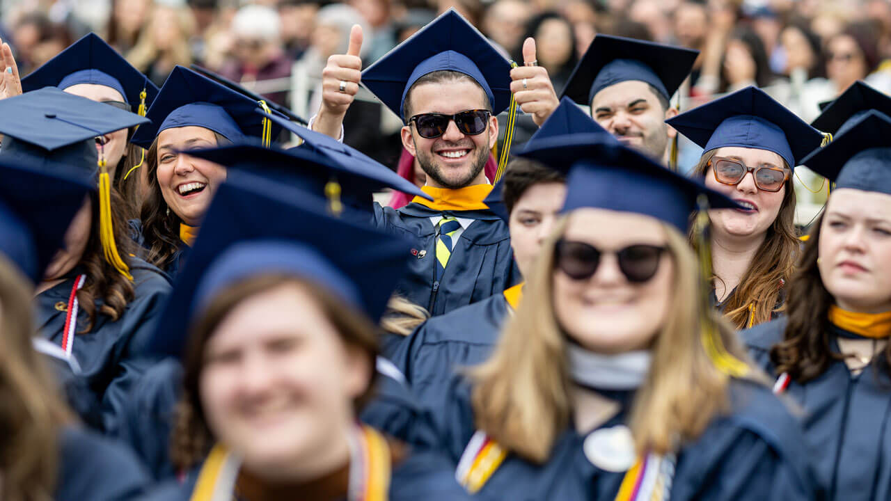 Graduate giving a thumbs up during SOC Commencement
