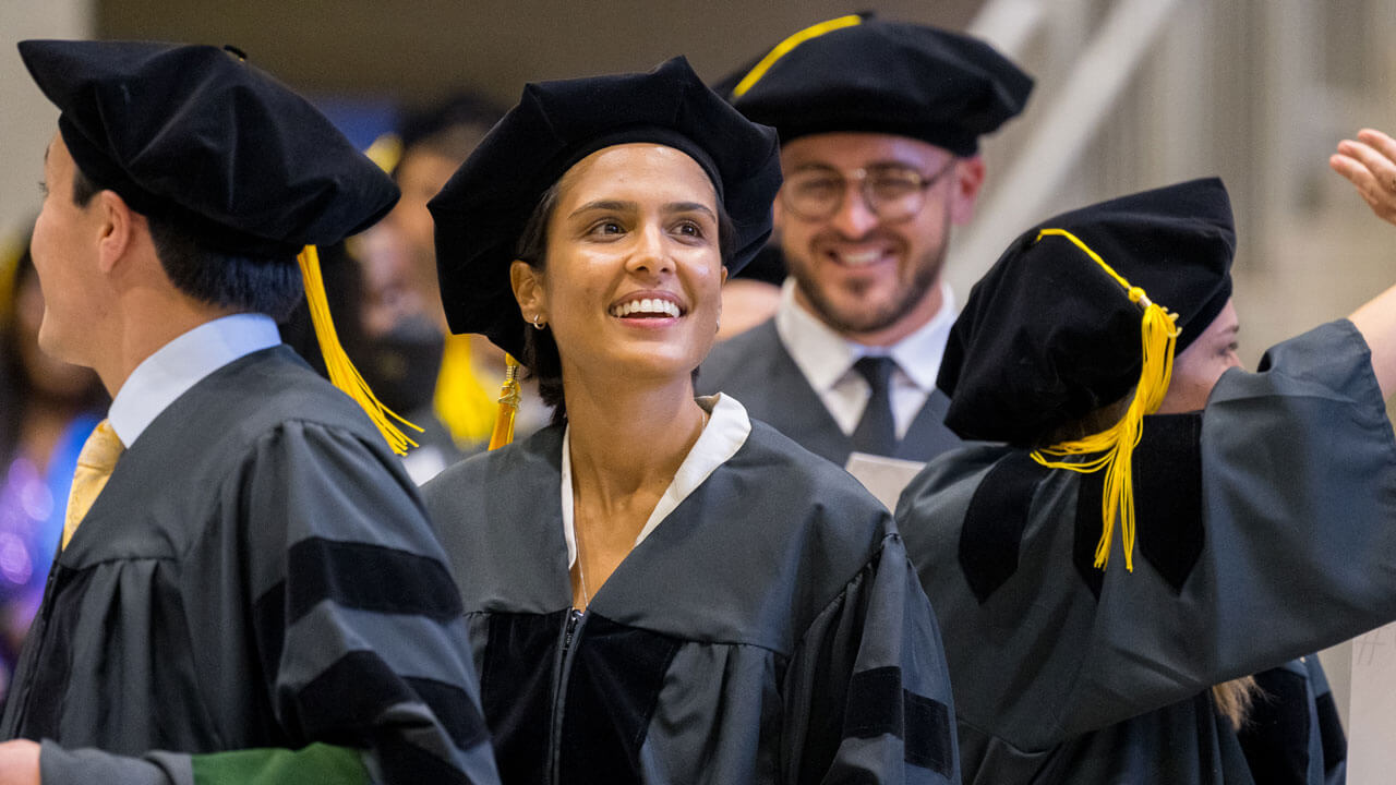 Student smiling and walking in line during graduation