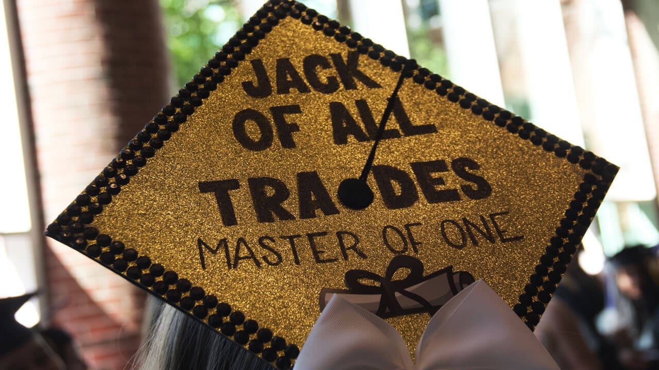 Gold and black cap graduation cap says 