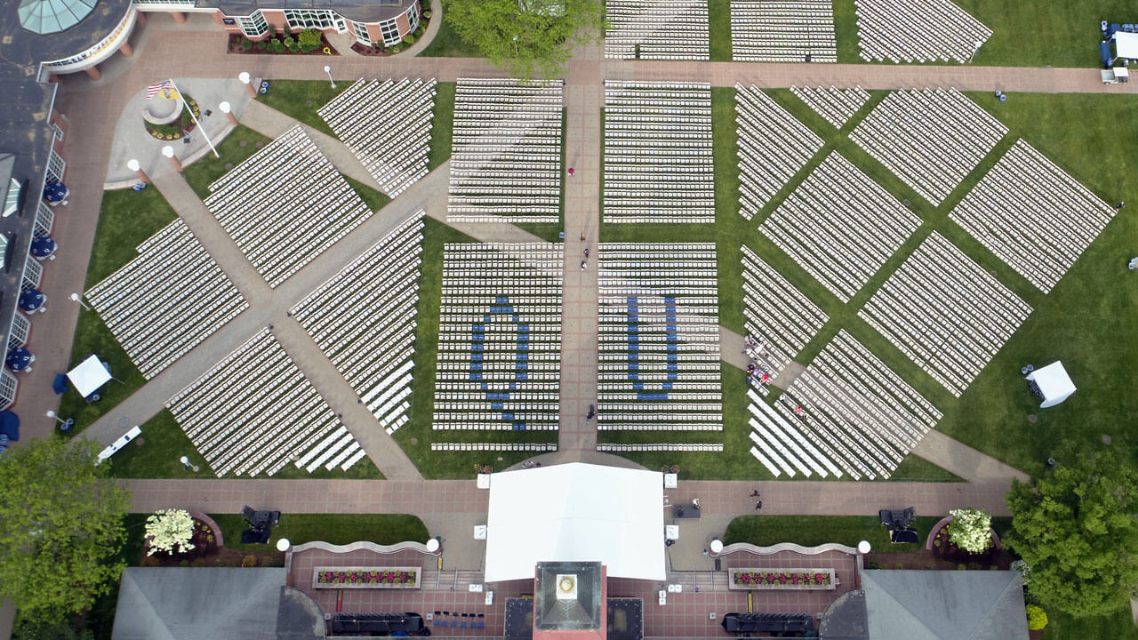 Aerial shot of commencement seating spelling out QU