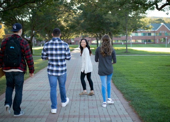 Four students walk across the quad to Echlin Center