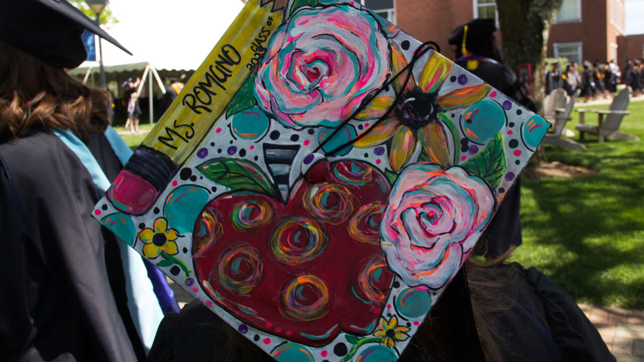 Graduate cap decorated in drawings of roses and squiggles