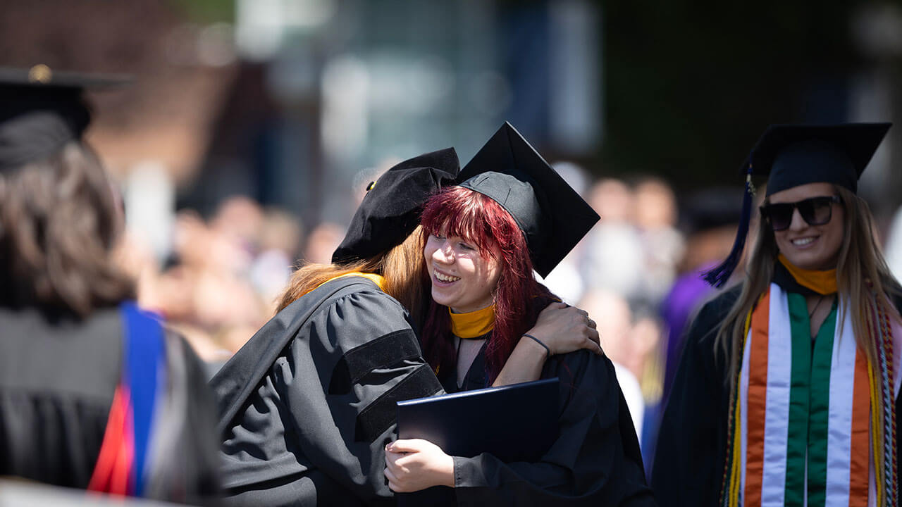 graduate tightly hugs her professor