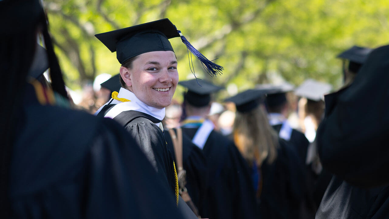 graduate turns around, grinning broadly