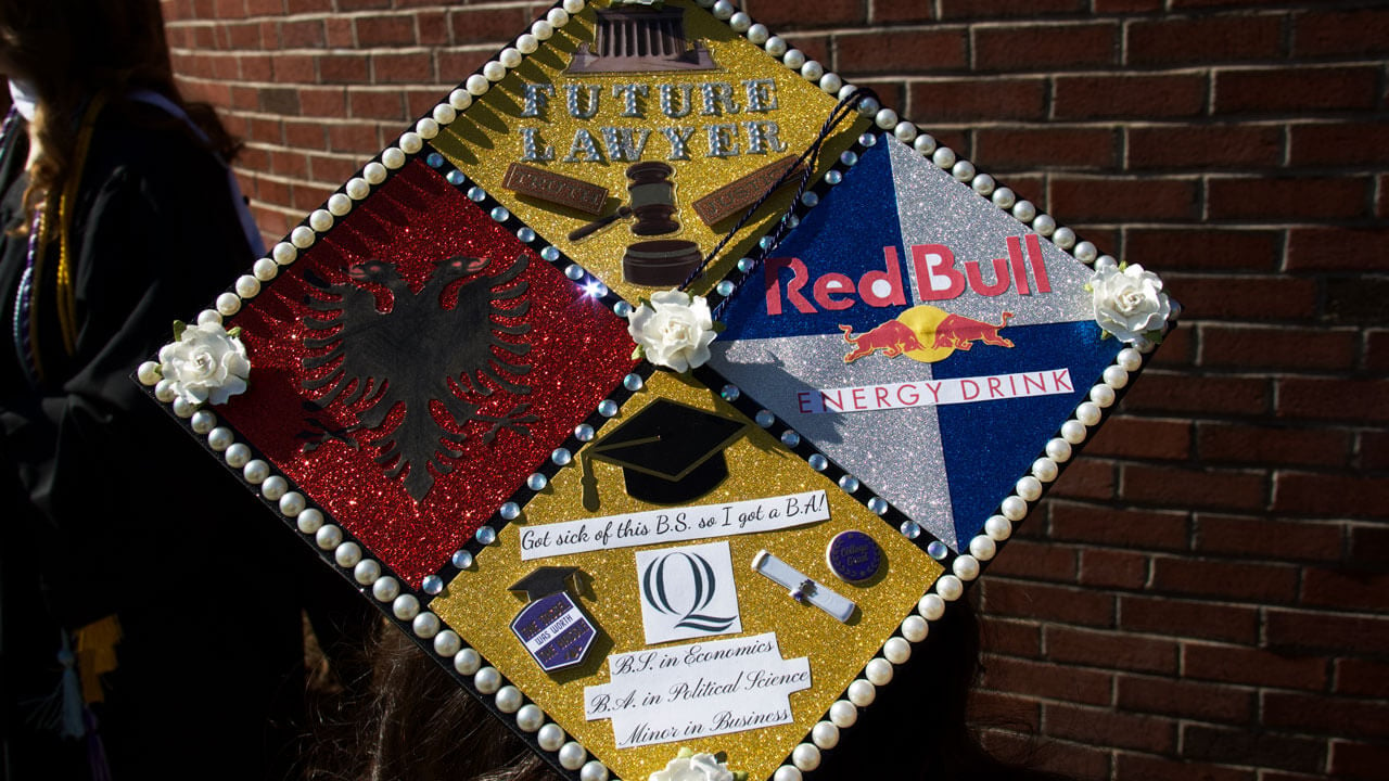 Graduate cap decorated in red and gold saying 
