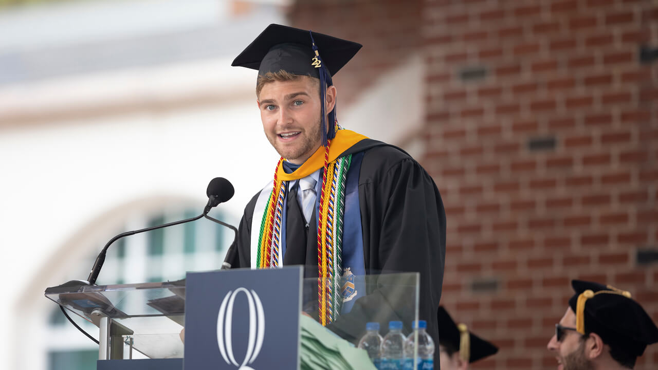 Alec Williams speaks from the podium during Commencement