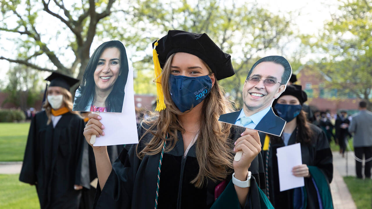 Graduate holding head cutouts