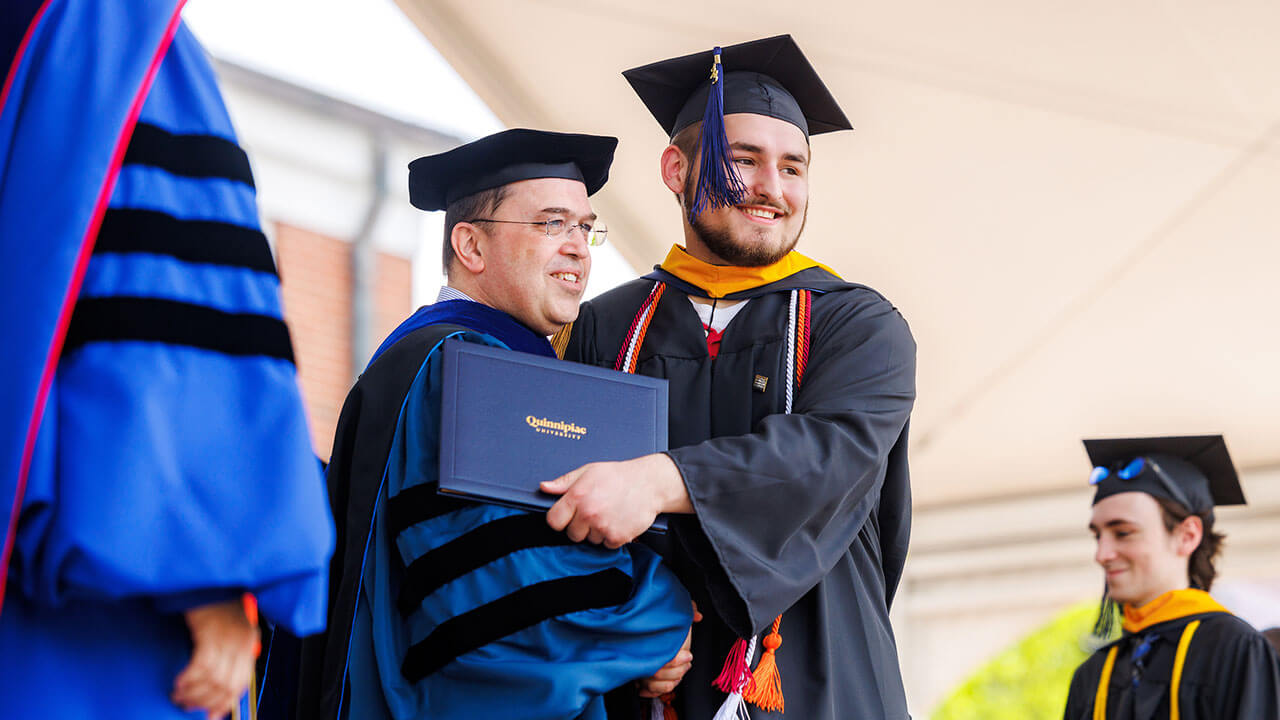 Graduate hugs the Dean of the School of Computing and Engineering