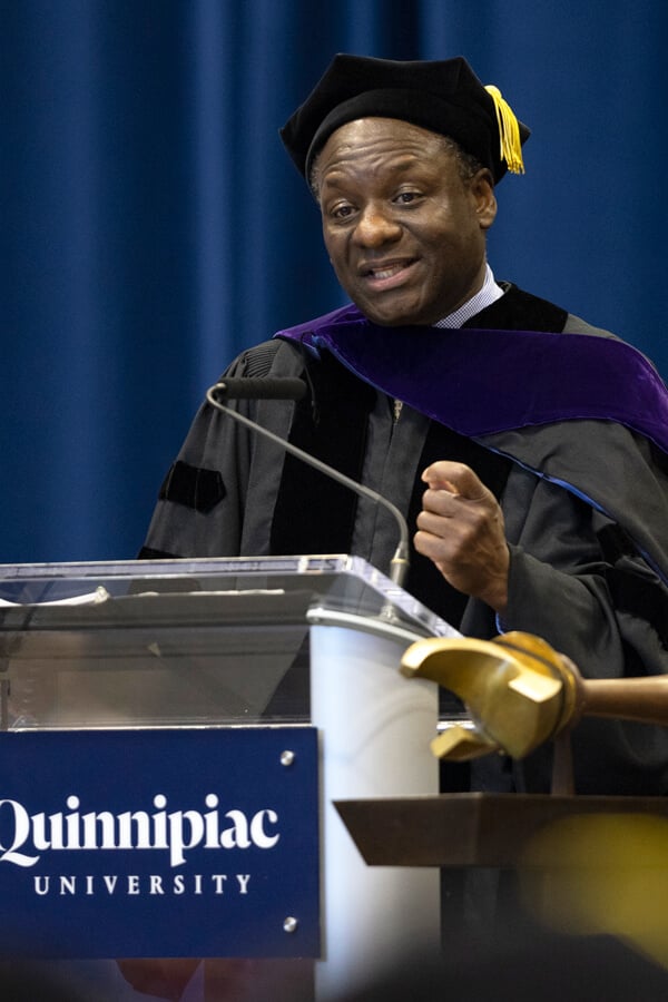 Honorable Victor A. Bolden speaks behind a podium at Quinnipiac Commencement