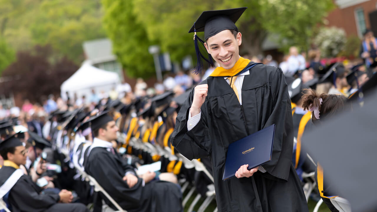 Graduate celebrates as he walks with his diploma