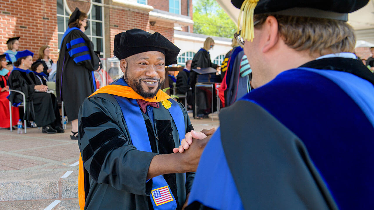 Faculty member shakes graduate's hand