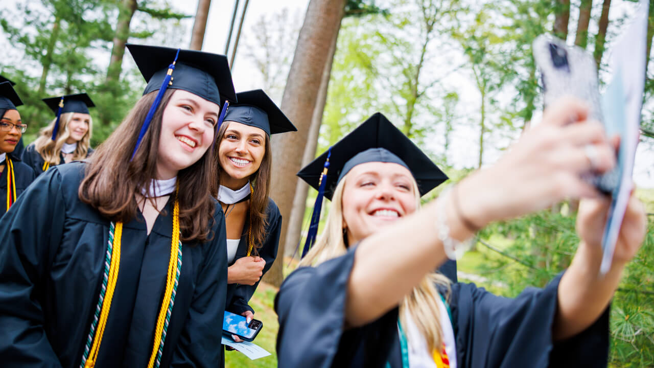Three graduates pose for a selfie