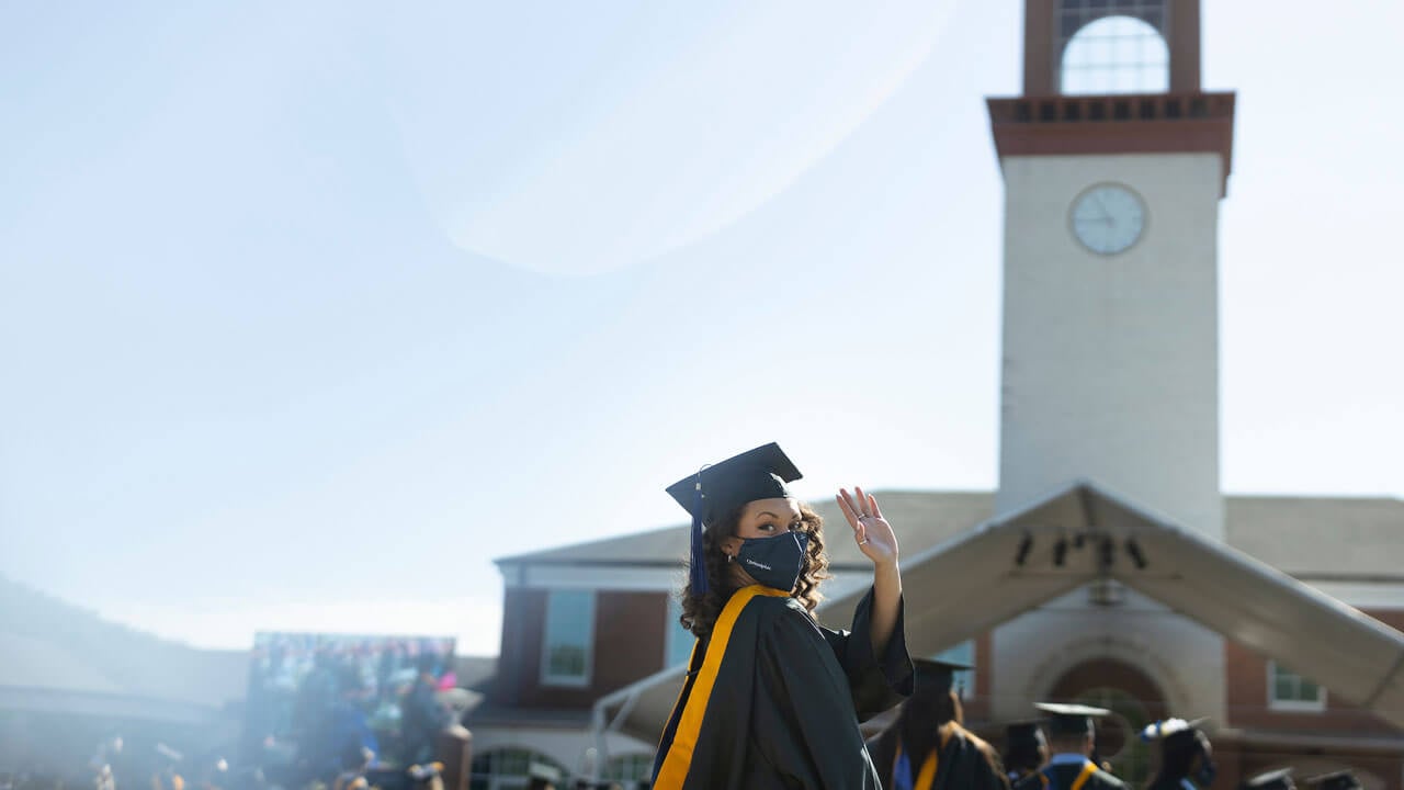 Graduate waving at camera