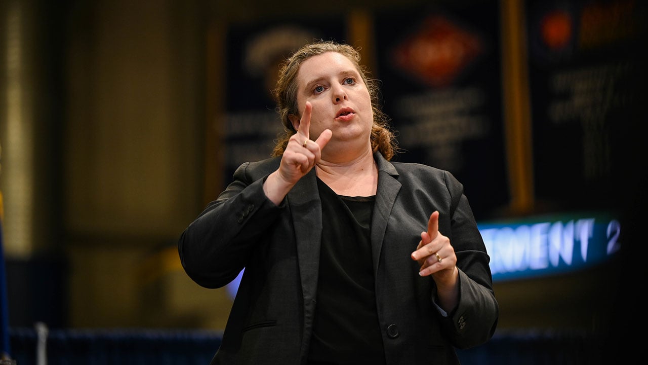 ASL sign language interpreter on stage during commencement