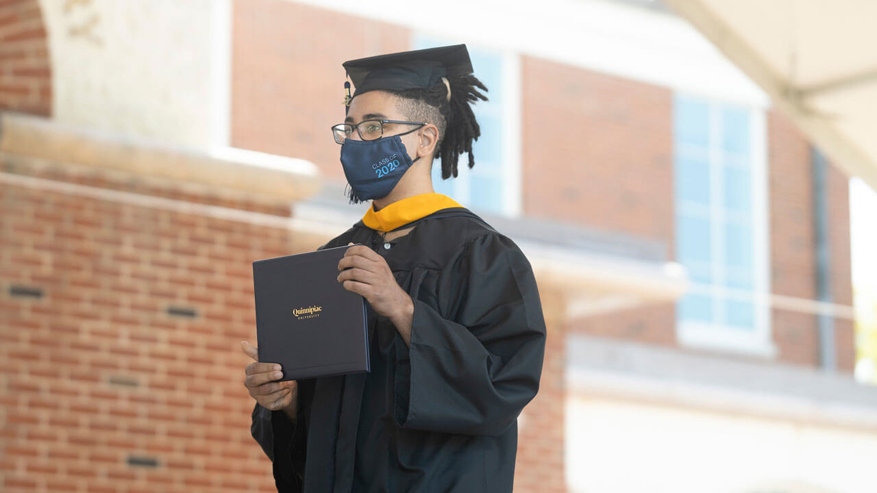 Graduate holding his diploma