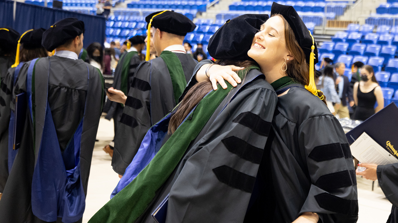 Graduates embrace after their ceremony