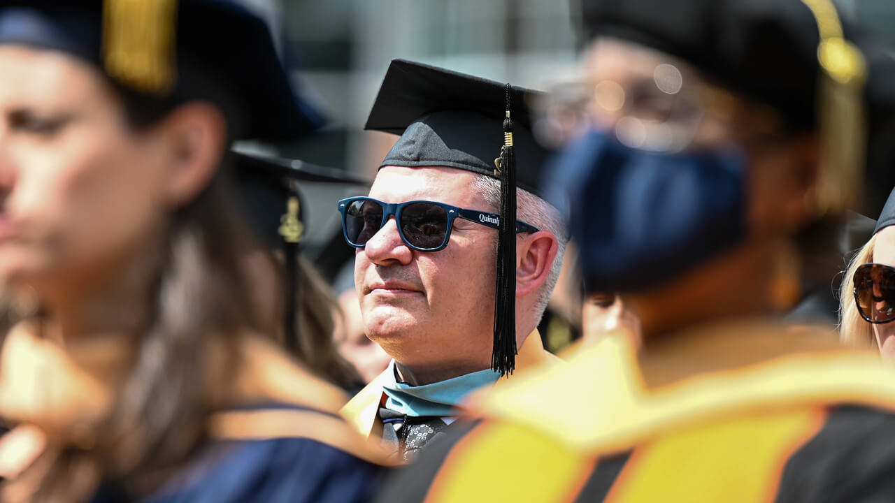 Graduate student in glasses looks at the stage