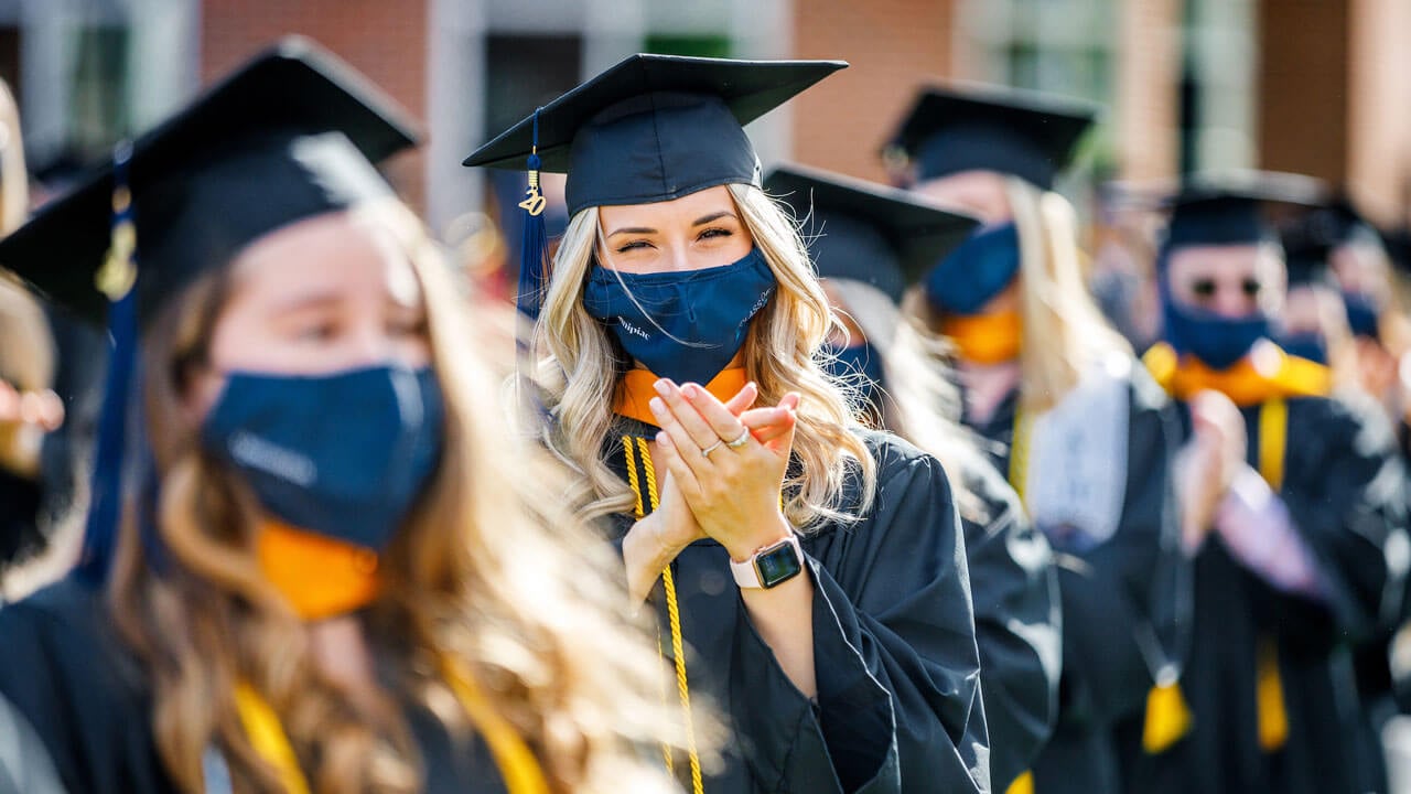 Graduate clapping during commencement ceremony
