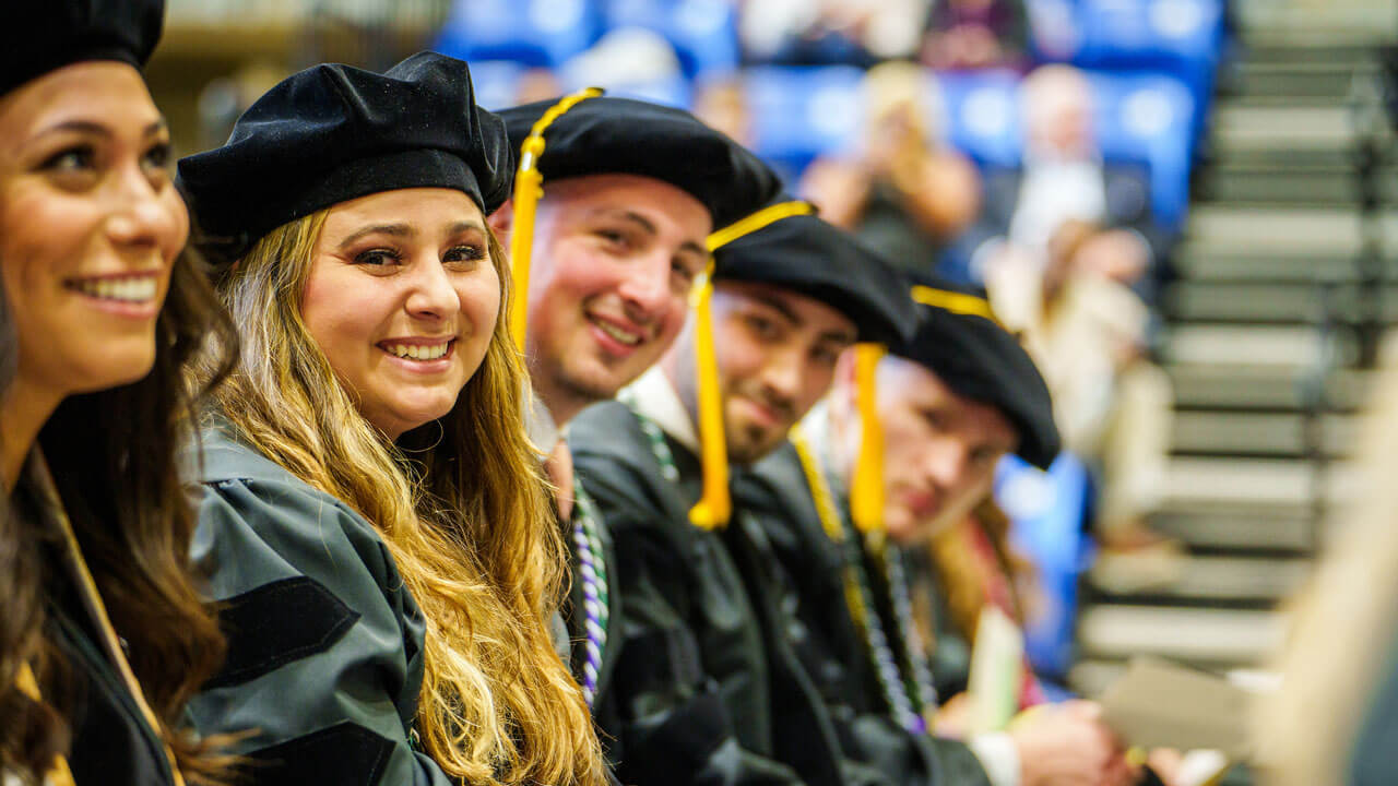 A line of graduating law students smile for the camera
