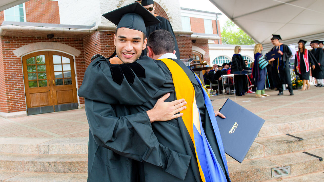 Graduate student hugs faculty member