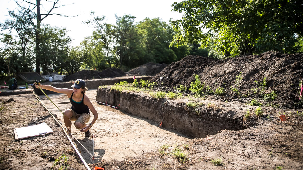 Student measures an area during an excavation project in Bekes, Hungary