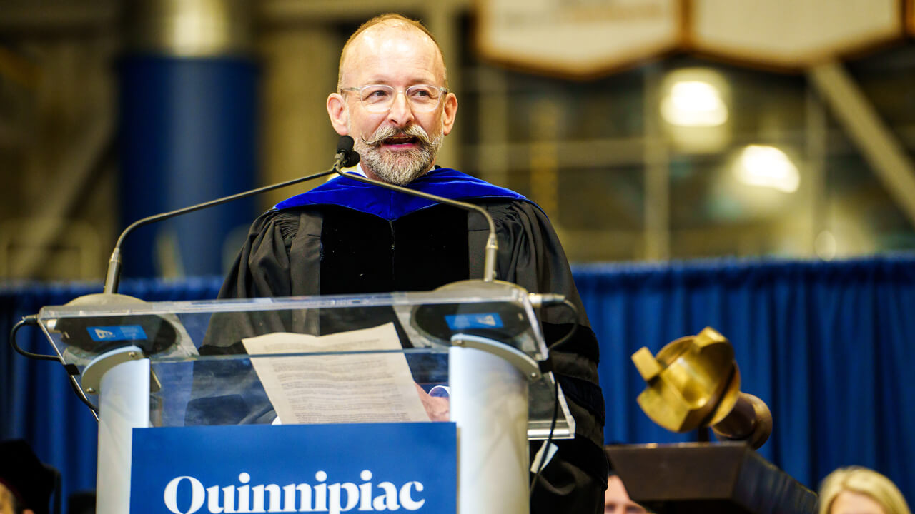 Auguste Fortin speaks from a podium during his commencement keynote address
