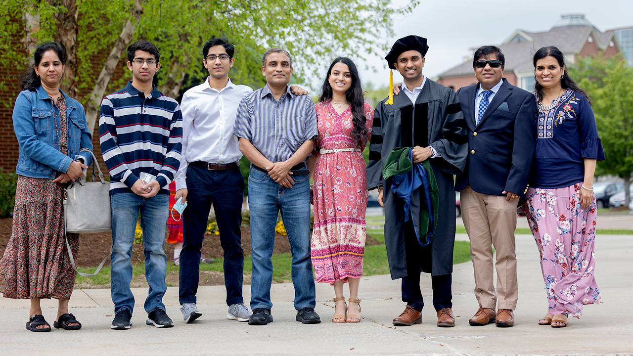A graduate stands surrounded by their family