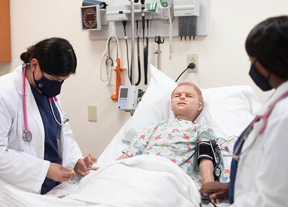 A student works with a simulated patient.