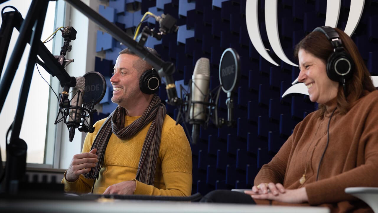 JT Torres and Karen Majeski in the podcast studio talking into microphones