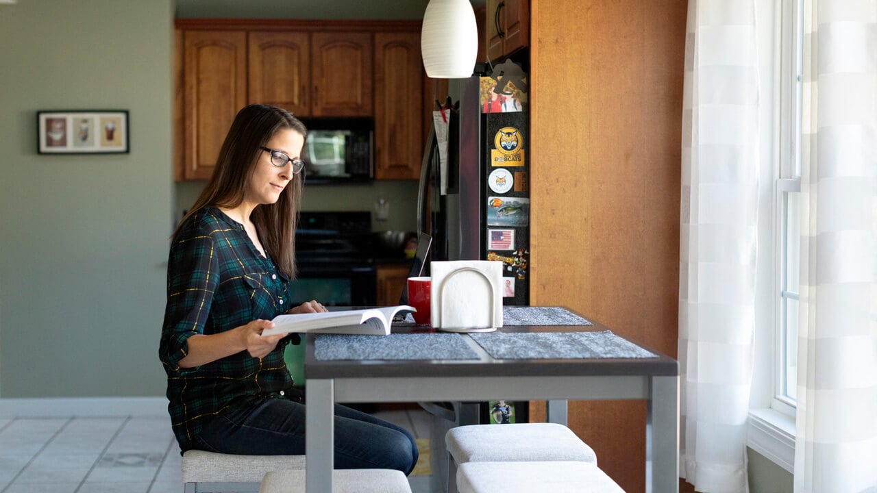 An adult student studying at her kitchen table