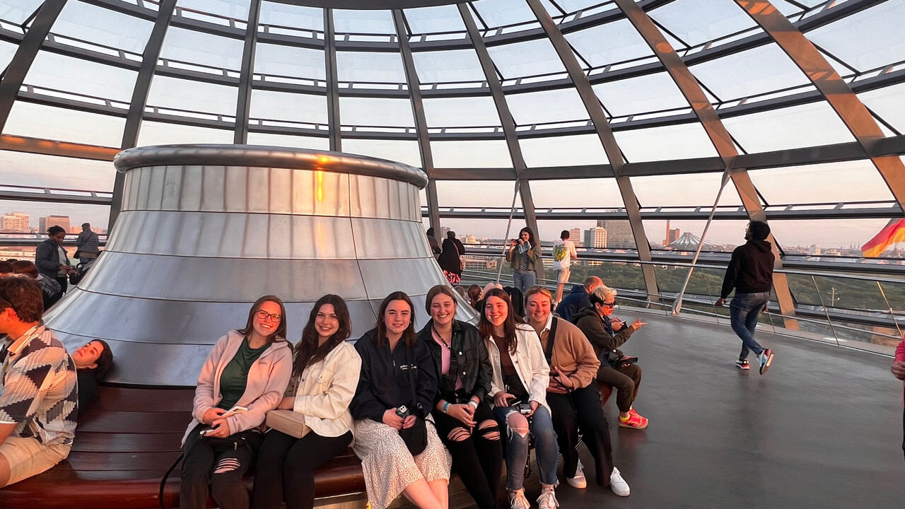 Group photo of students sitting inside glass dome
