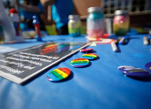 Table with LGBTQ+ pins and materials.
