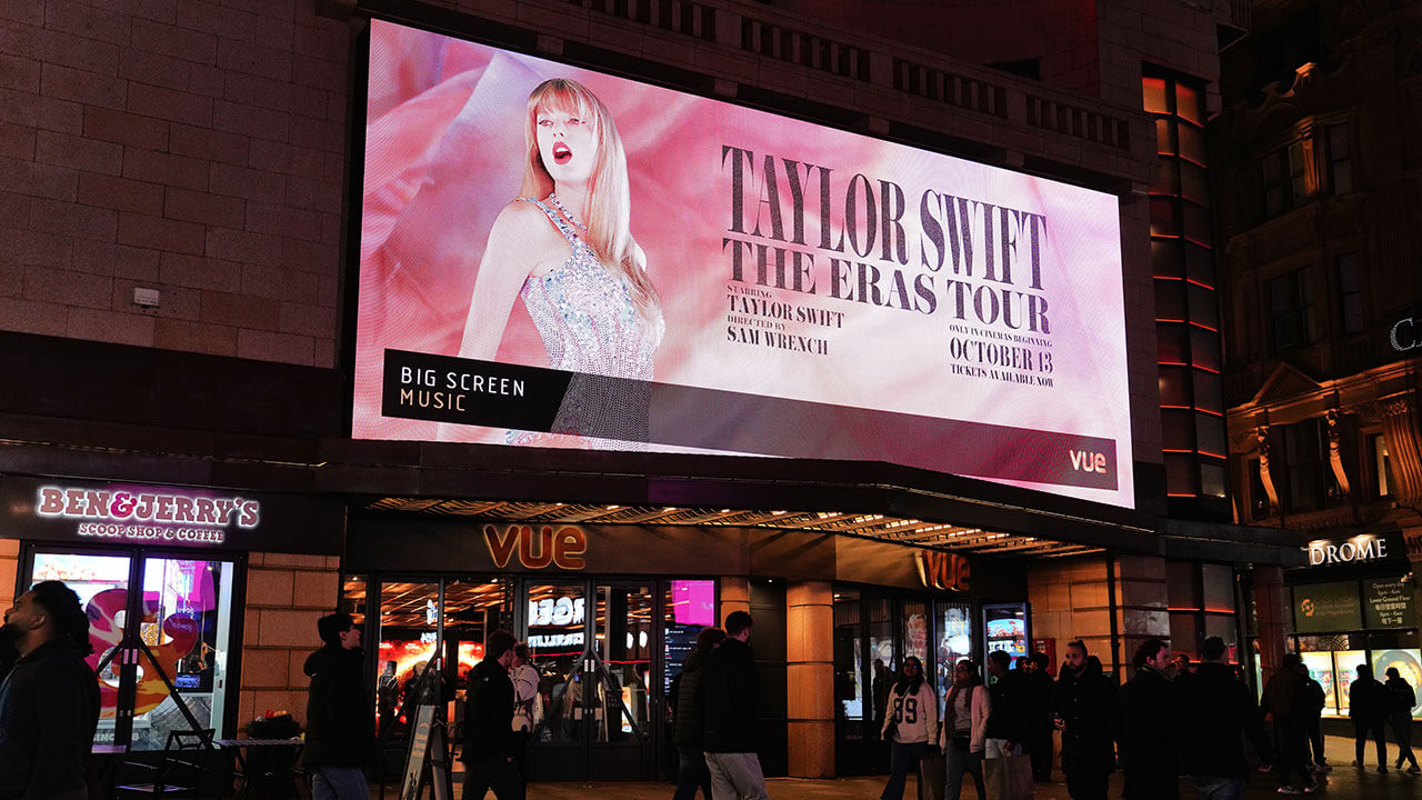 A Taylor Swift billboard over an arena.