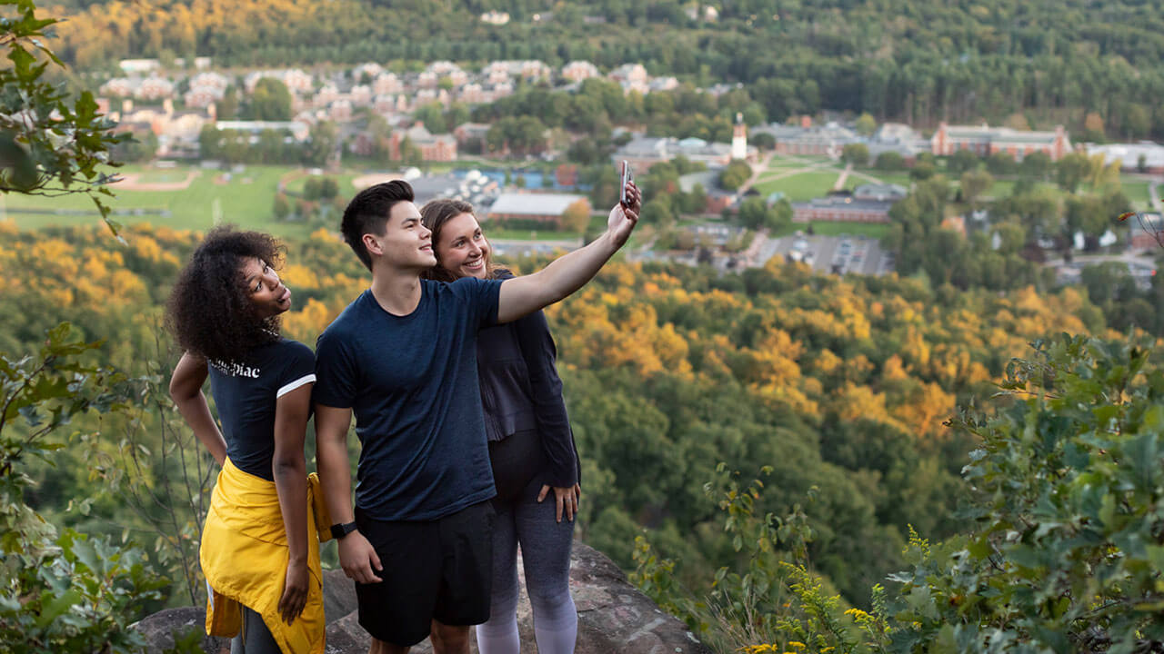A group of students take a picture at the top of Sleeping Giant State Park